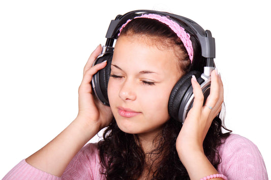 young girl wearing headphones, eyes closed, enjoying music