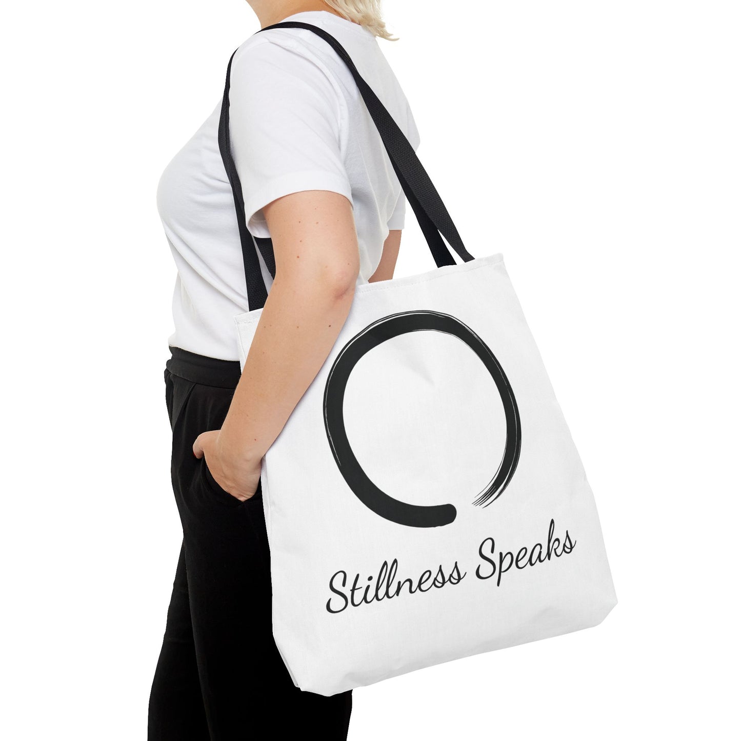 Person holding a white tote bag with 'Stillness Speaks' text and symbol.