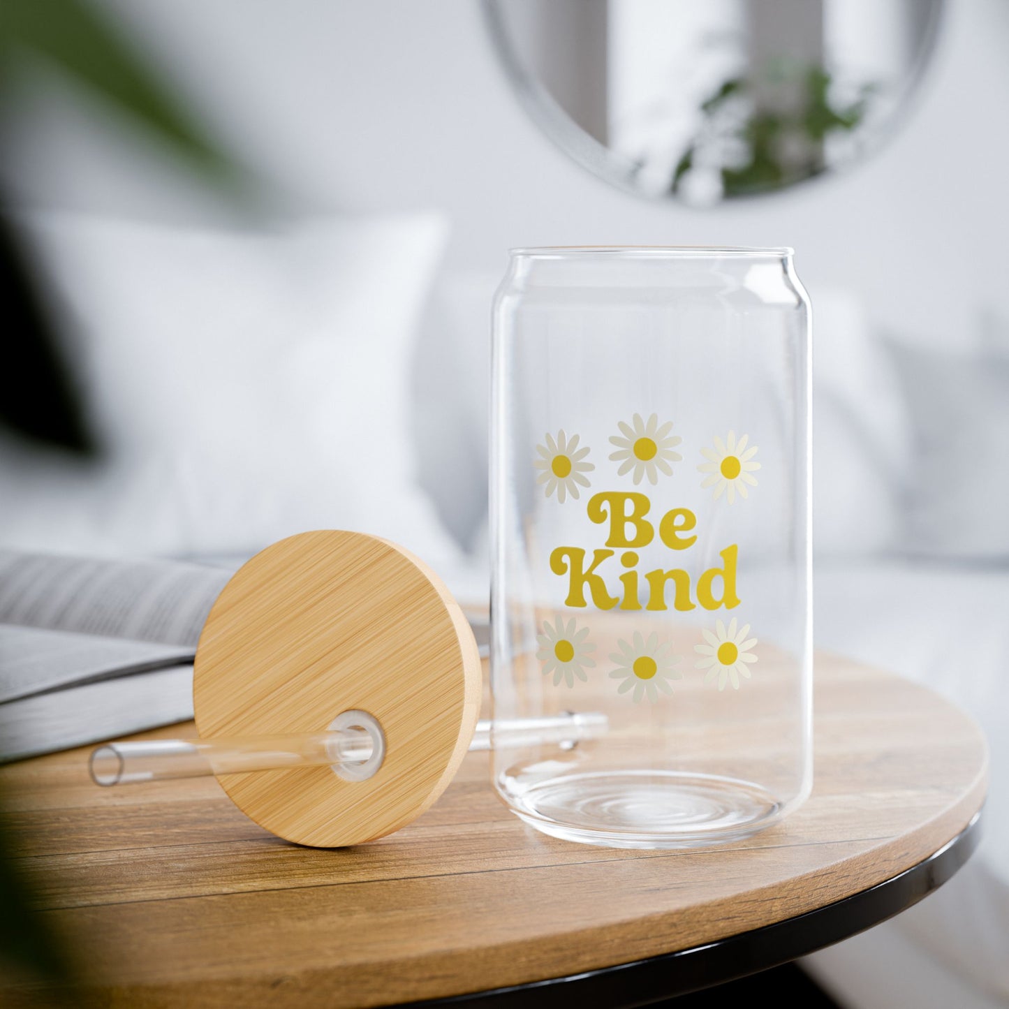 Clear glass tumbler with wooden lid and 'Be Kind' text on a wooden surface.