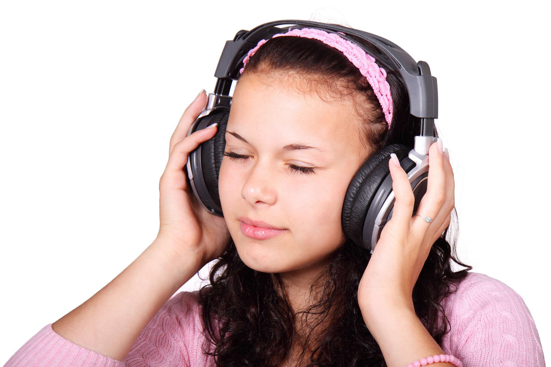 young girl wearing headphones, eyes closed, enjoying music