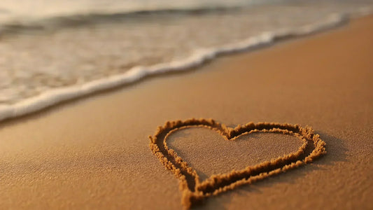 Kindness blog hero—heart drawn in wet sand as a wave approaches