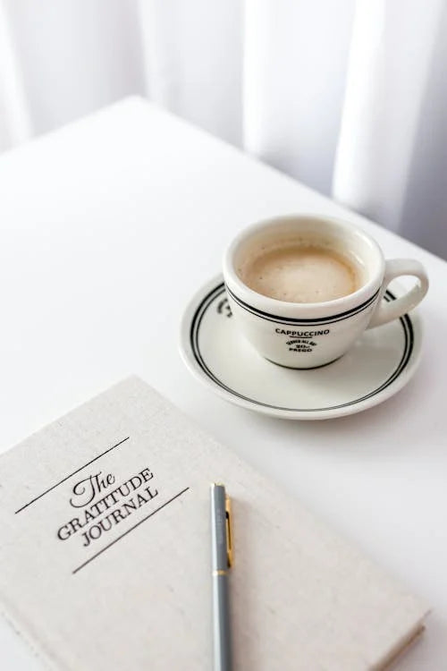 Flat lay of a gratitude journal with cappuccino — inspiring mindful reflection and gratitude practices.