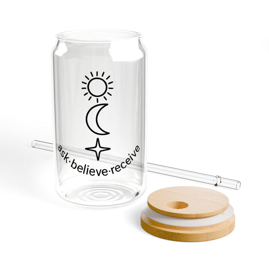 Clear glass tumbler with sun, moon, and star design, lid, and straw on a white background