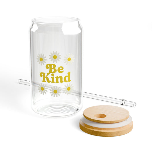 Clear glass tumbler with 'Be Kind' text and daisy flowers, including a straw and wooden lid on a white background.