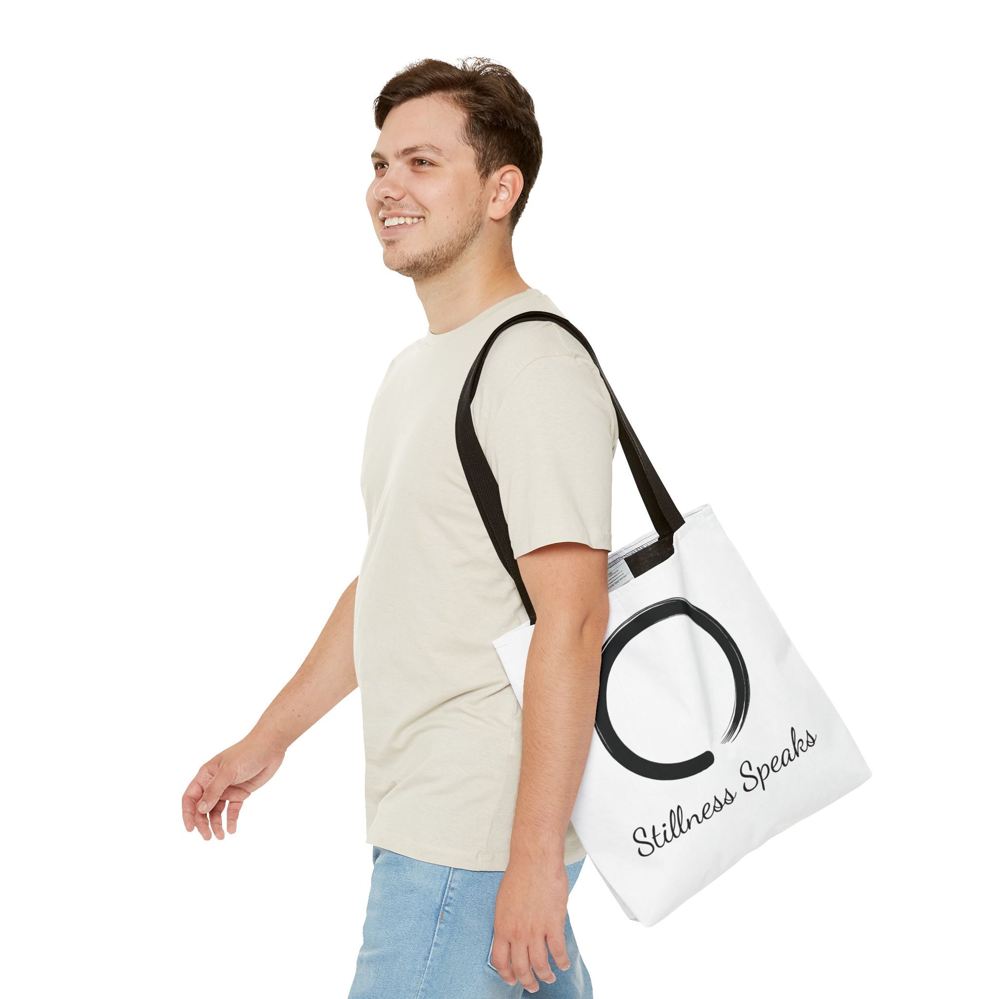 Man carrying a tote bag with 'Stillness Speaks' text on a white background