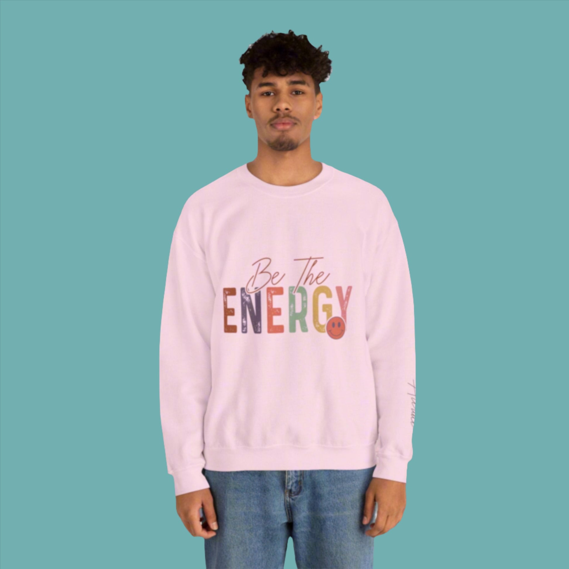 man wearing unisex pink be the energy you want to attract sweatshirt