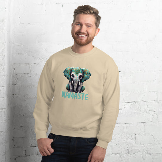Man wearing a beige sweatshirt with an elephant graphic and 'Namaste' text against a white brick wall.