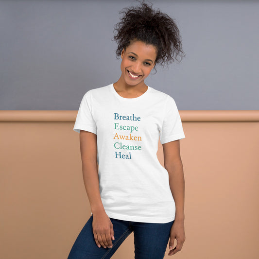 Woman wearing a white t-shirt with motivational phrases on a plain background