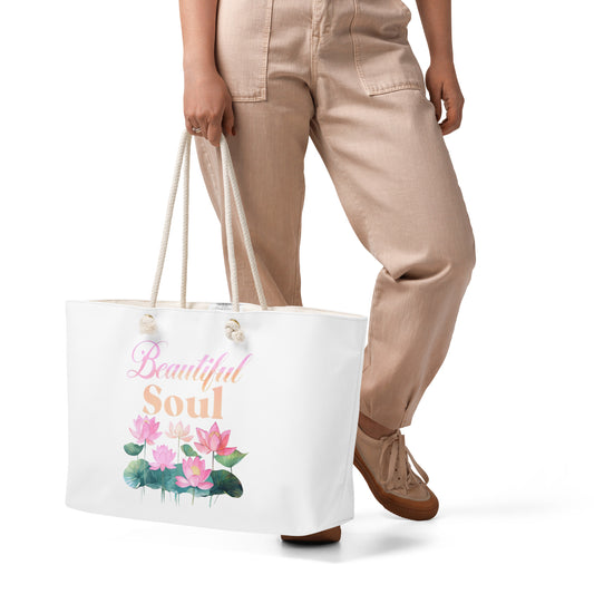 Person holding a tote bag with floral design and 'Beautiful Soul' text on a white background